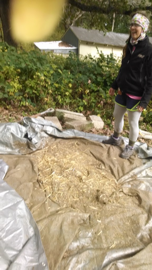 Andrea Blaha, doing the mud stomp with straw, clay and sand to form the second thermal layer of cob.